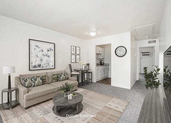 A living room with a couch, coffee table, and a painting on the wall at Newport Village Apartments, Portage, MI
