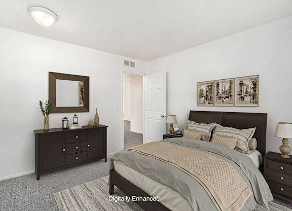 A bedroom with a bed, dresser, and mirror at Newport Village Apartments, Portage, MI