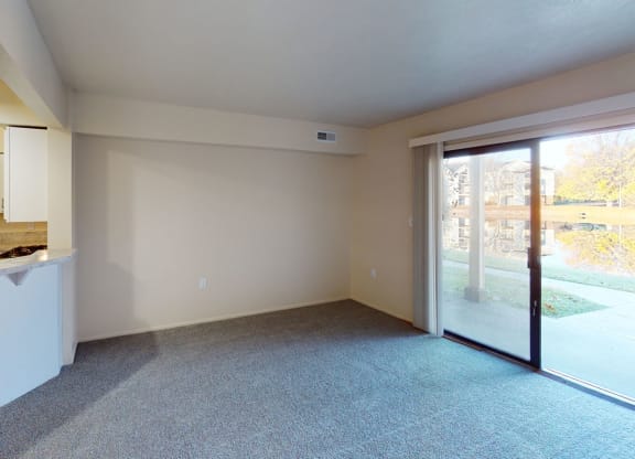 a living room with a kitchen and a sliding glass door at North Pointe Apartments in Elkhart, IN