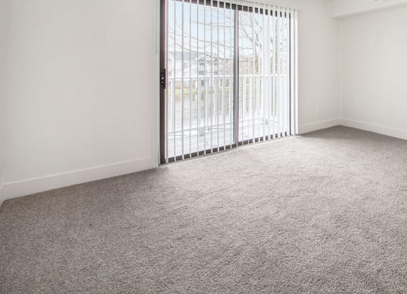 Living room with a sliding glass door at North Pointe Apartments in Elkhart, IN