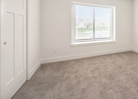Bedroom with carpet and a window at North Pointe Apartments in Elkhart, IN