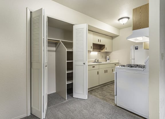 a kitchen with white appliances and a closet at Normandy Village Apartments, Michigan City