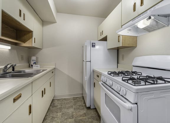 Galley kitchen with a stove and refrigerator and a sink at Normandy Village Apartments, Indiana, 46360