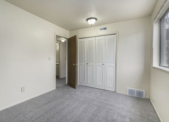 Bedroom with a large window and closet at Normandy Village Apartments, Indiana, 46360