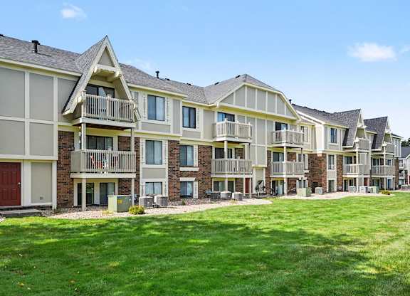 A large apartment building with balconies and red doors at Normandy Village Apartments in Michigan City, IN