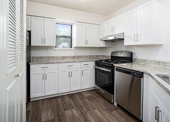 A kitchen with white cabinets, a window, and stainless steel appliances at North Pointe Apartments in Elkhart, IN