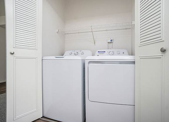 A washing machine and dryer in a small laundry room at North Pointe Apartments in Elkhart, IN