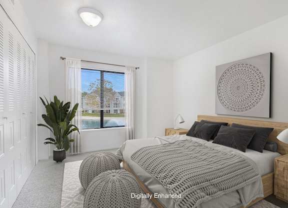 A bedroom with a large bed and a large window with a view at North Pointe Apartments, Elkhart