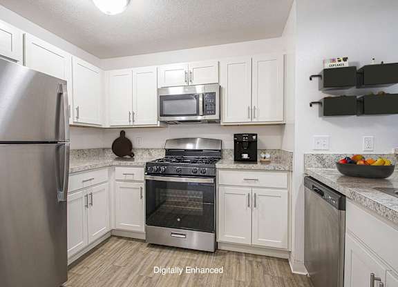 A kitchen with white cabinets and a stainless steel appliances at North Pointe Apartments, Elkhart