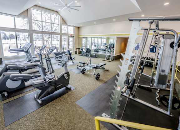 A gym with a variety of equipment including treadmills, stationary bikes, and weight machines  at Northport Apartments, Macomb, MI, 48044
