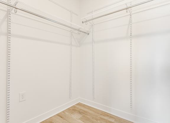 A white wall with a wooden floor and a white ceiling with a white pipe at Nuvo Flats, Indiana, 46410