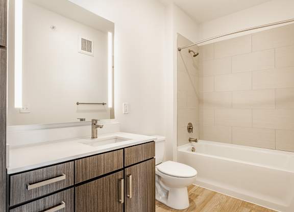 A white toilet sits next to a white sink in a bathroom at Nuvo Flats, Indiana, 46410