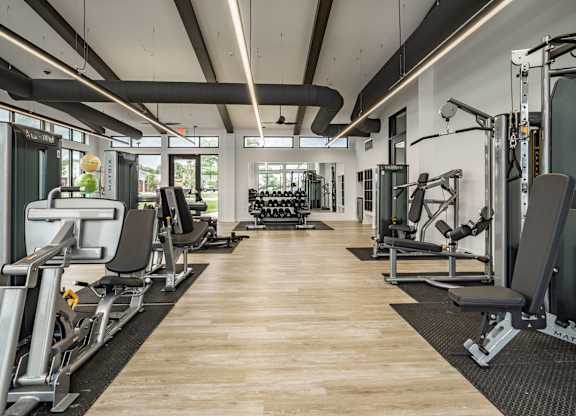 A gym with a variety of equipment including weights and machines.