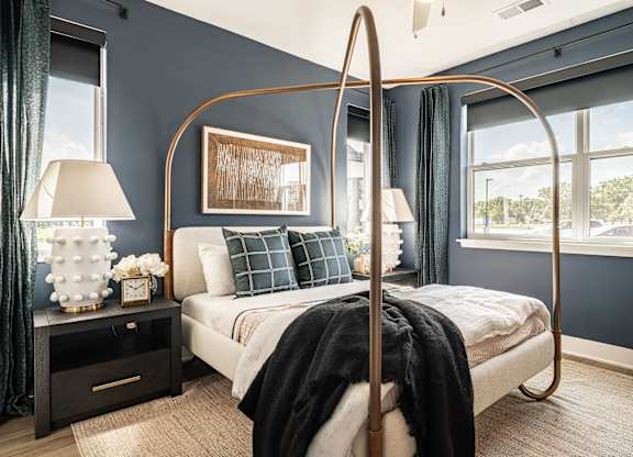 A bedroom with a four poster bed and a window.