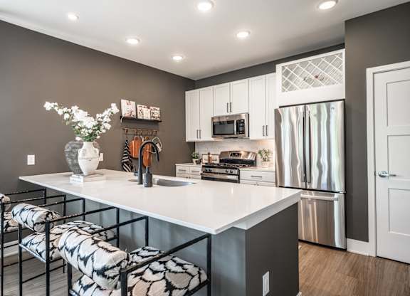 A kitchen with a white countertop and a refrigerator.