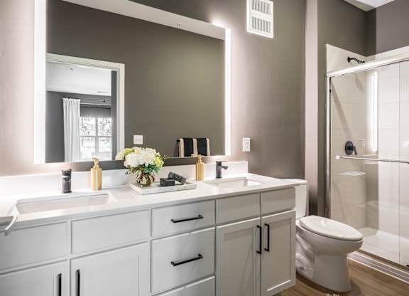 A bathroom with a white sink and a white toilet.