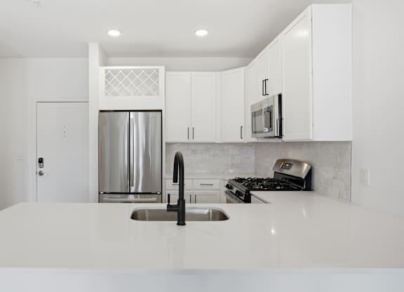 A modern kitchen with white cabinets and appliances at Nuvo Flats, Indiana, 46410