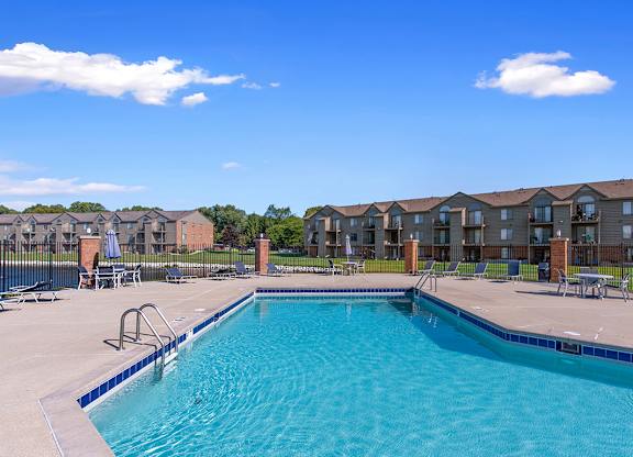 A swimming pool in front of apartment buildings at Oak Shores Apartments in Oak Creek, WI
