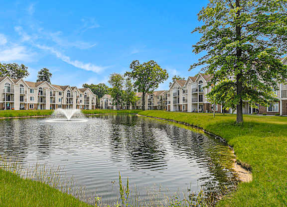 A fountain in the middle of a pond in front of apartment buildings at Orchard Lakes Apartments, Toledo, 43615