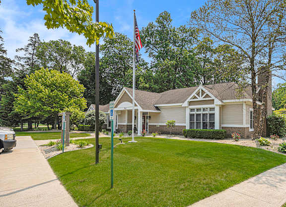 A leasing office with a flag on a pole in front of it at Orchard Lakes Apartments, Toledo, 43615