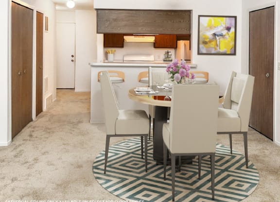 a dining area with a table and chairs and a kitchen in the background  at Northport Apartments, Michigan, 48044