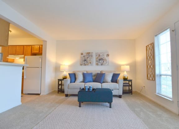a living room with a couch and a coffee table  at Northport Apartments, Macomb, 48044