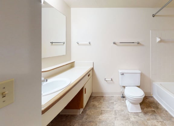 main bathroom with a toilet and a sink and a bath tub at Pine Knoll Apartments, Battle Creek, 49014