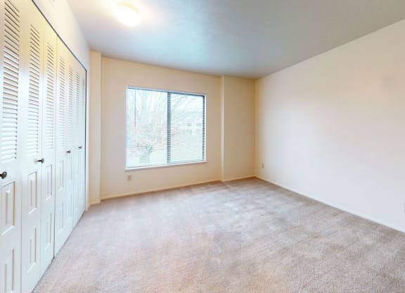 spacious bedroom with a large window and closet at Pine Knoll Apartments, Battle Creek, 49014