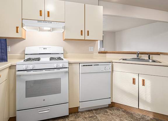 A kitchen with a white stove and white oven.