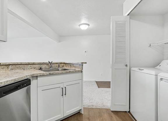 A kitchen with a laundry area with a washer and dryer at Pine Knoll Apartments, Battle Creek