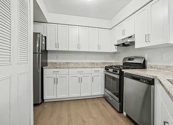 A kitchen with white cabinets and stainless steel appliances at Pine Knoll Apartments, Battle Creek