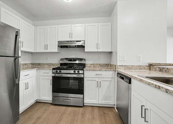 A kitchen with white cabinets and stainless steel appliances at Pine Knoll Apartments, Battle Creek