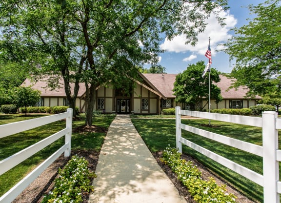 the front of a clubhouse with a white fence and a path leading up to it  at Polo Run Apartments, Indiana, 46142