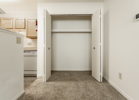 a bedroom with an open closet and a kitchen at Polo Run Apartments, Greenwood, Indiana