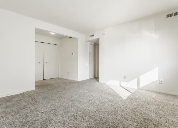 an empty living room with white walls and tile floor at Polo Run Apartments, Indiana