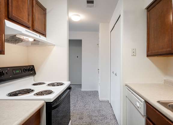 A kitchen with a stove top oven and a dishwasher at Polo Run Apartments, Greenwood, Indiana