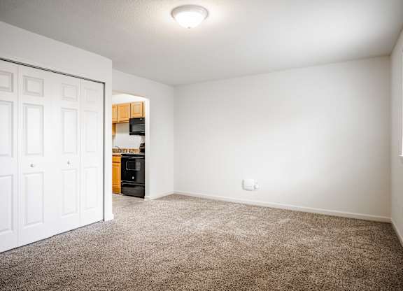A room with a white door and a brown carpet at Polo Run Apartments, Greenwood, 46142