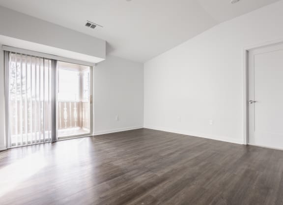 an empty living room with wood floors and a sliding glass door at Polo Run Apartments, Indiana, 46142