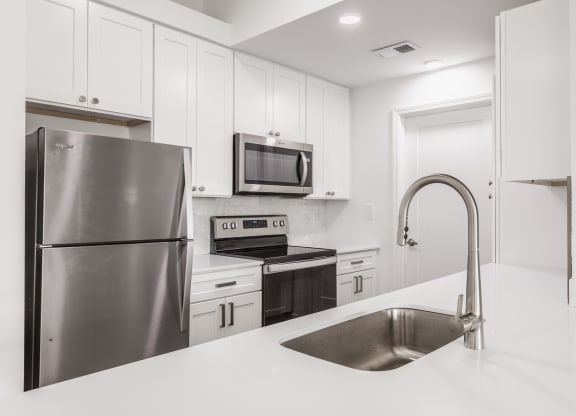 a white kitchen with stainless steel appliances and a sink at Polo Run Apartments, Indiana, 46142