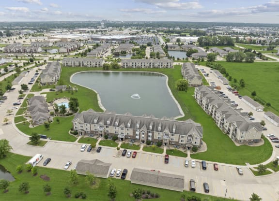 drone view of scenic community with pond fountains at Hunters Pond Apartment Homes, Champaign, 61820