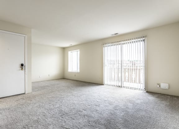 an empty living room with a door to a balcony at Scarborough Lake Apartments, Indiana, 46254