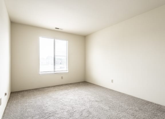 an empty room with carpet and a window at Scarborough Lake Apartments, Indianapolis, IN