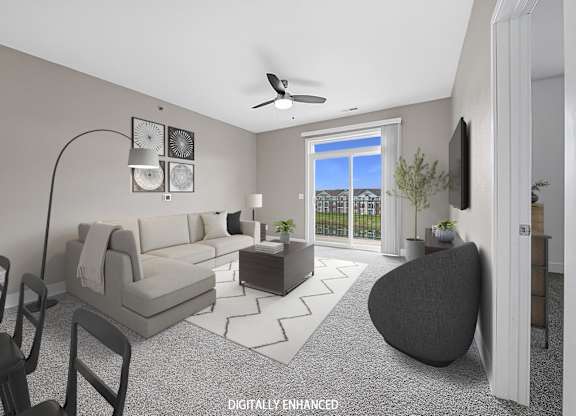 A modern living room with a 9' ceiling, grey sofa, a black armchair at The Reserve at Destination Pointe apartments, Grimes, IA
