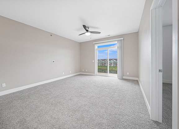 A living room with a 9' ceiling and ceiling fan at The Reserve at Destination Pointe, Iowa