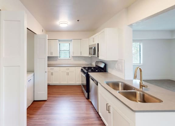 an empty kitchen with white cabinets and a sink at Green Ridge Apartments, Grand Rapids, 49544