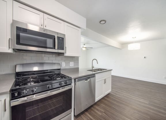 a kitchen with a stove top oven next to a sink at Green Ridge Apartments, Grand Rapids, MI
