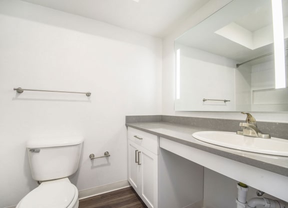 a bathroom with a toilet sink and mirror at Green Ridge Apartments, Grand Rapids, Michigan