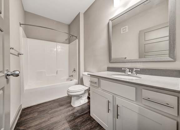A bathroom with a toilet, sink, and shower. at River Crossing Apartments, Missouri, 63303