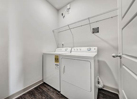 A white washer and dryer in a laundry room. at River Crossing Apartments, St. Charles, 63303
