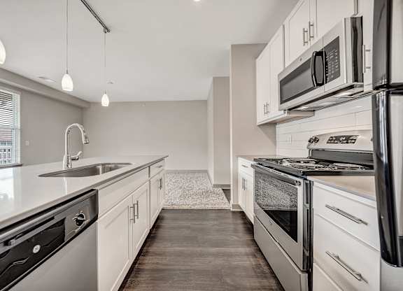 A modern kitchen with stainless steel appliances and white cabinets.at River Crossing Apartments, St. Charles, 63303